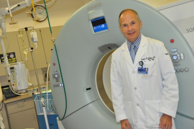 Dr. Doug Fellows stands next to a CT scanner at the UConn Medical Center, which is used for advanced imaging. Photo credit: Shawn Kornegay