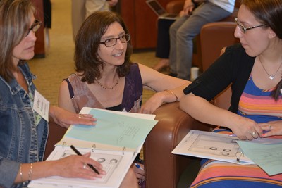 Megan Staples, associate professor of mathematics education, center, speaks with two teachers from Manchester High School, Cathy Mazzotta, left, and Adrianne Satin, during a workshop at the Neag School of Education. (Shawn Kornegay/UConn photo)
